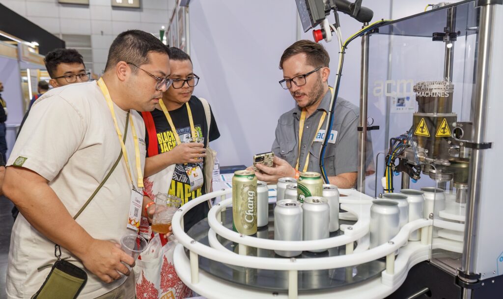 A canning machine manufacturer talks with brewers at Brew asia 2025 in Bangkok